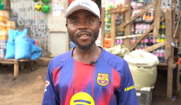 Health worker Paluku Audrey stands at a market in Bunia, Ituri Province. The 29-year-old must enter communities to explain to distrusting residents about the risks of Ebola infection