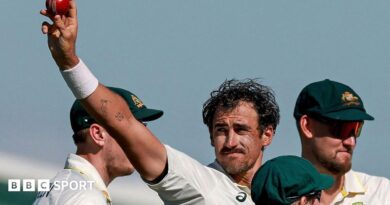 Australia cricketer Mitchell Starc celebrates his 10th wicket in the match by holding the ball up