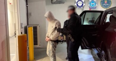 a photo of australian police walking with one of the alleged TeamPCP hackers in handcuffs