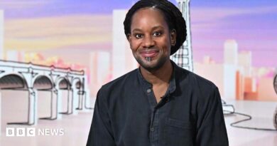 Jason Arday wears a black shirt and smiles at the camera as he appears as a guest on the panel of BBC show Sunday with Laura Kuenssberg