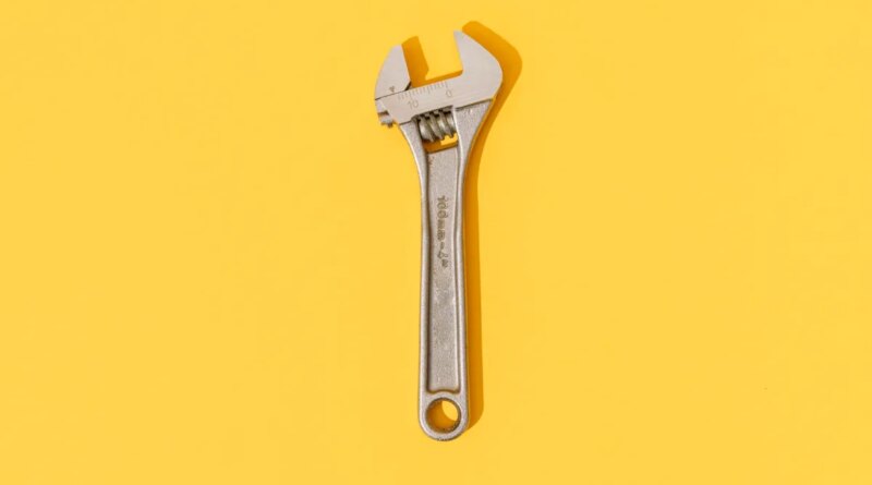 Adjustable wrench on yellow background