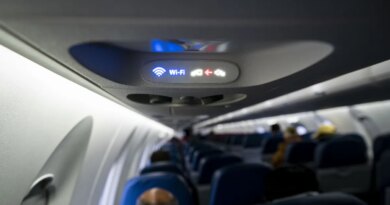 A Wi-Fi and fasten seat belts sign illuminated on a Delta Air Lines plane.