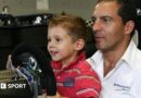 A young Kimi Antonelli sitting in a go-kart while wearing racing overalls and a racing helmet