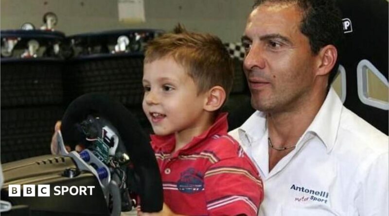 A young Kimi Antonelli sitting in a go-kart while wearing racing overalls and a racing helmet