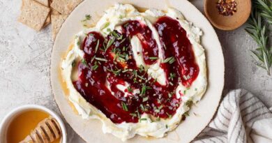 goat cheese dip topped with raspberry jam, fresh rosemary, and red pepper flakes served with crackers and hot honey