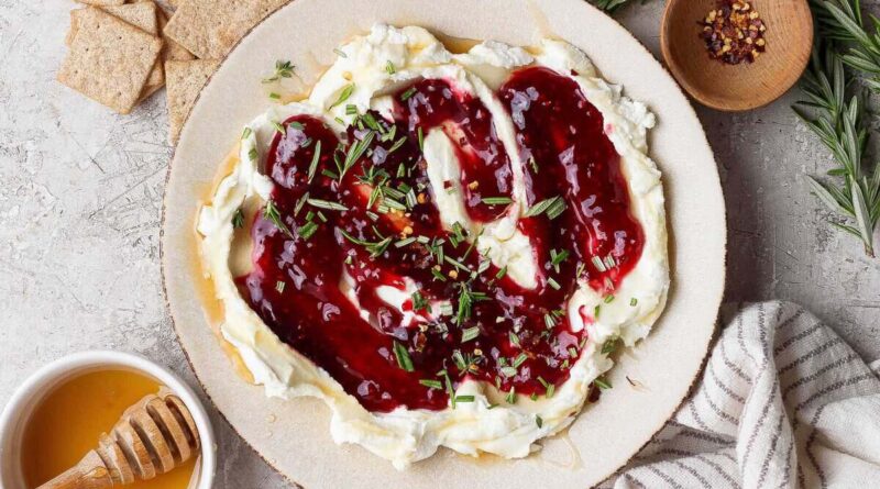 goat cheese dip topped with raspberry jam, fresh rosemary, and red pepper flakes served with crackers and hot honey
