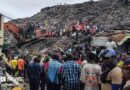 Rescuers use an excavator to comb through a mountain of scattered rubbish at a major waste site in Conakry, Guinea, as local residents gather nearby. Photo: 23 August 2026