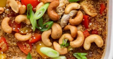 Cashew chicken casserole with bell peppers, cashews, and green onions in a white dish.