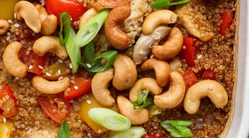 Cashew chicken casserole with bell peppers, cashews, and green onions in a white dish.