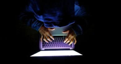 Hooded hacker Man with laptop stealing personal data from internet