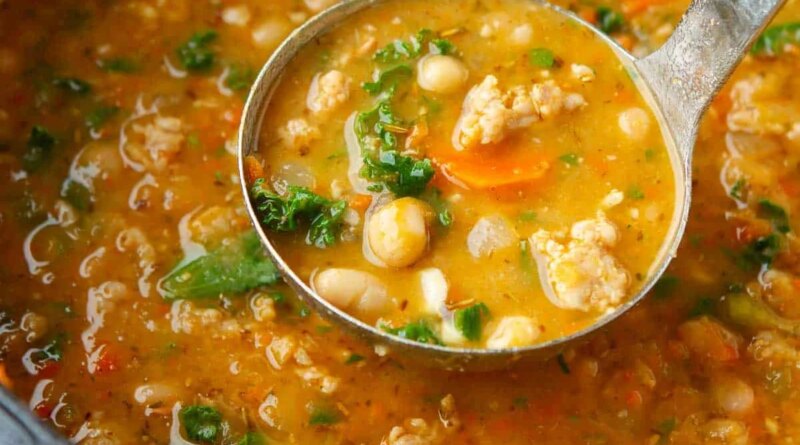 Sausage, bean and kale soup in a saucepan.