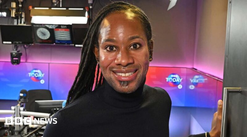 Jason Arday smiling in the doorway of a BBC radio studio in December 2023