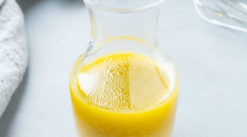 A small glass carafe filled with Maple Dijon Dressing.