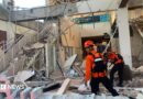 Emergency workers look through the rubble at Lauren Say port in Maumere