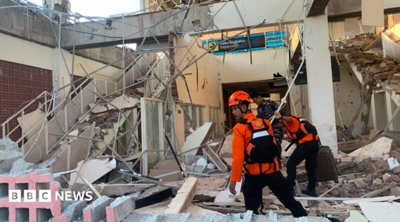 Emergency workers look through the rubble at Lauren Say port in Maumere