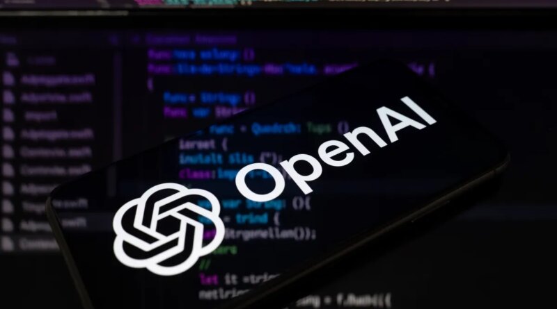 The OpenAI logo is displayed on a smartphone screen placed on a reflective surface onto which lines of computer code.