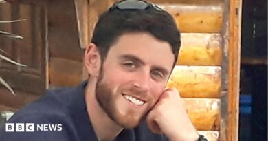 Andrew Harper is pictured - he is a man with short brown hair and a slight beard wearing a shirt and smiling at the camera.
