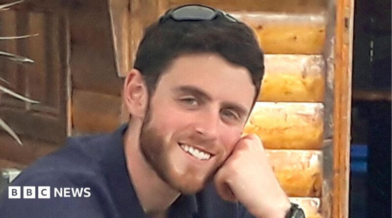Andrew Harper is pictured - he is a man with short brown hair and a slight beard wearing a shirt and smiling at the camera.