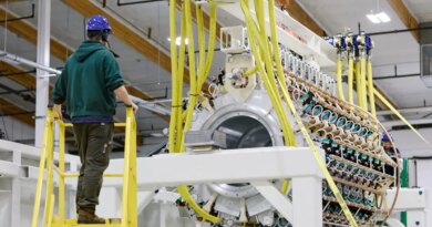 A Pacific Fusion employee inspects a pulser prototype.