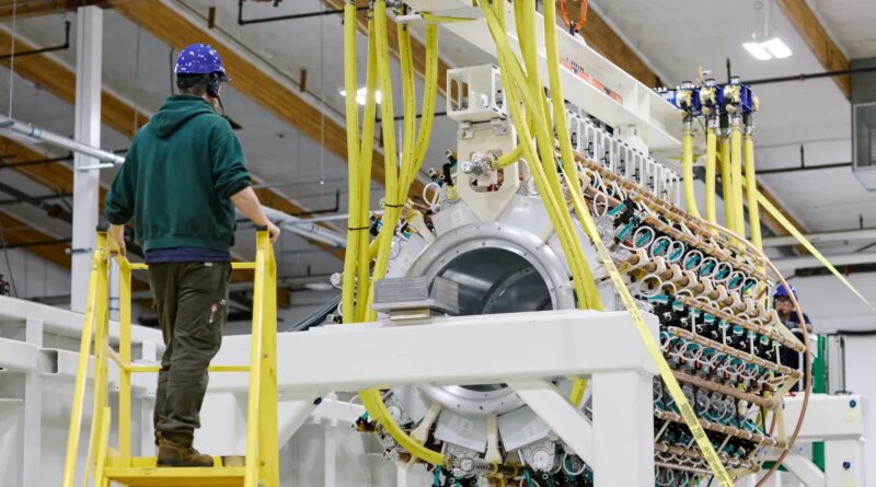 A Pacific Fusion employee inspects a pulser prototype.