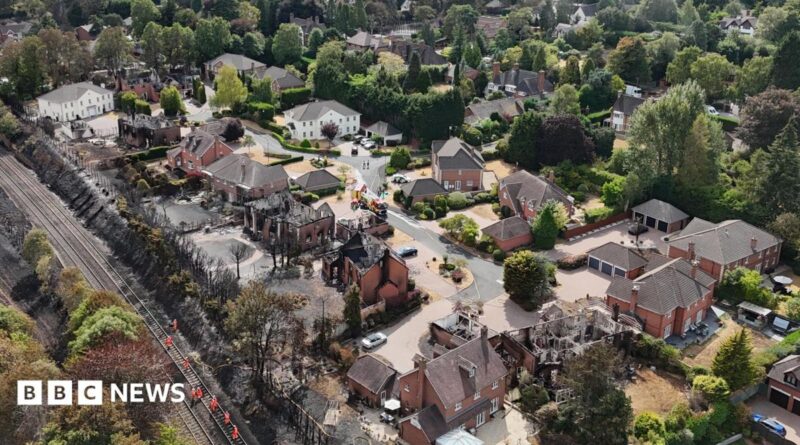 An aerial view of the devastation that wildfires have taken on an area of Stourbridge. Several houses are blackened or destroyed, with a field behind the houses completely black.