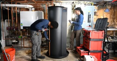 Two plumbers install a new water heater.