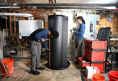 Two plumbers install a new water heater.