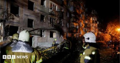 Firefighters work at the site of an apartment building hit by a Russian missile strike in Kyiv