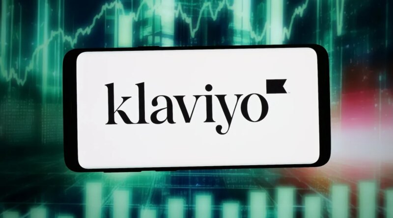 The logo of US marketing automation company Klaviyo Inc. is seen displayed on a smartphone in front of an abstract background on a computer screen.