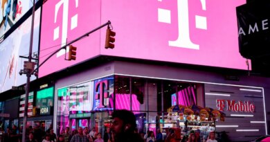 a t-mobile store in NYC in Times Square with bright pink lights on a billboard with T-Mobile's logo