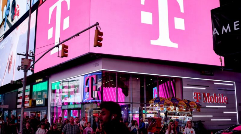 a t-mobile store in NYC in Times Square with bright pink lights on a billboard with T-Mobile's logo
