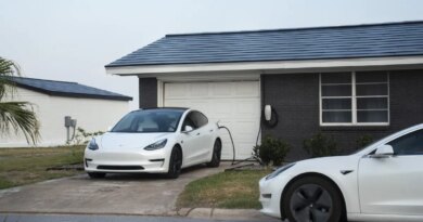 Tesla vehicles parked outside a home with a Tesla Solar Roof.