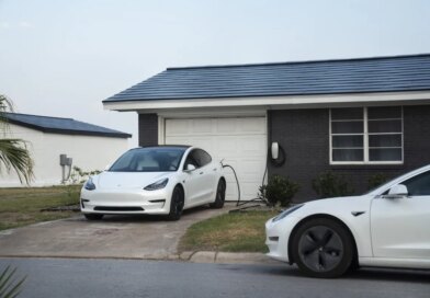 Tesla vehicles parked outside a home with a Tesla Solar Roof.