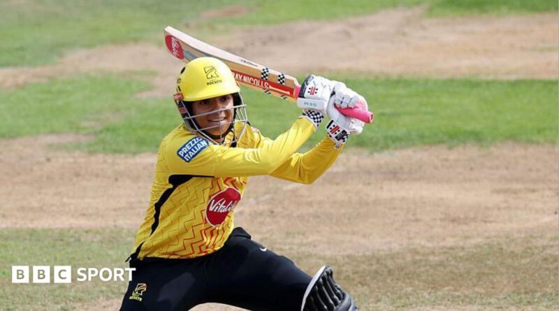 Sophia Dunkley, wearing a yellow helmet and shirt, plays a shot with her bat over her left shoulder