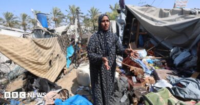 A Palestinian woman stands amid debris at a tent camp in Khan Younis.