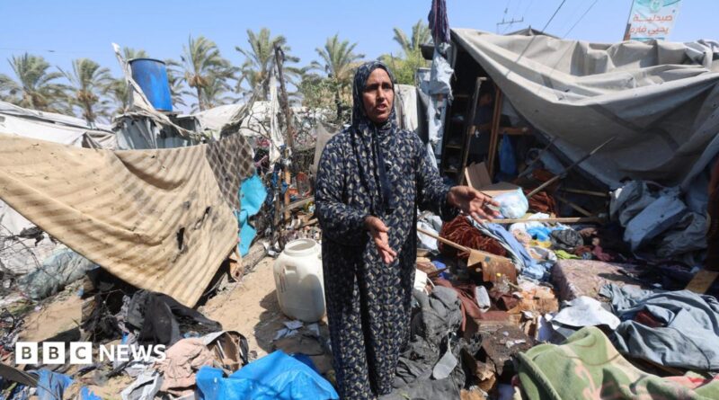A Palestinian woman stands amid debris at a tent camp in Khan Younis.