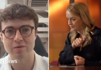 Jacob Coxon, shown on the left, wearing dark frame glasses and a white collored shirt. On the right is BBC's Laura Kuenssberg in a black shirt sitting with her arms on a desk as she looks to the left of frame.