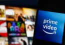The logo of Amazon Prime Video against a blurred backdrop of tiles on a television screen.
