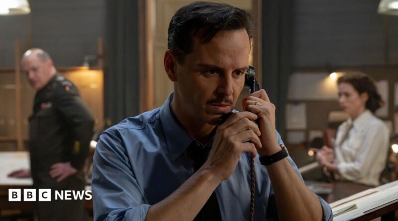 Andrew Scott in a wartime shirt with a small moustache and clipped, short hair - he is on the phone on the set of the film, looking tense