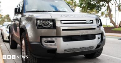 A silver Land Rover Defender parked on a road