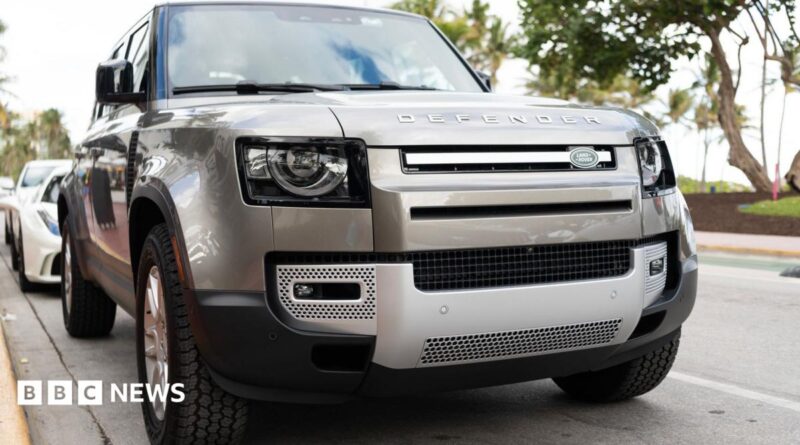 A silver Land Rover Defender parked on a road