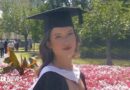 Cardiff student who 'brushed off' sore throat developed sepsis A girl with curly dark hair, wearing a white dress and black graduation cap and gown. She is stood in front of a flowerbed of pink flowers, with trees and people in the background, and is smiling at the camera.