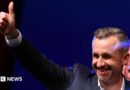 Ulrich Siegmund, leader of the AfD in the state, raises a thumbs up at the election party.