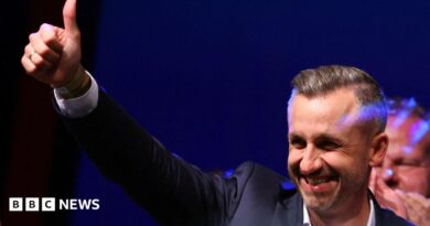 Ulrich Siegmund, leader of the AfD in the state, raises a thumbs up at the election party.