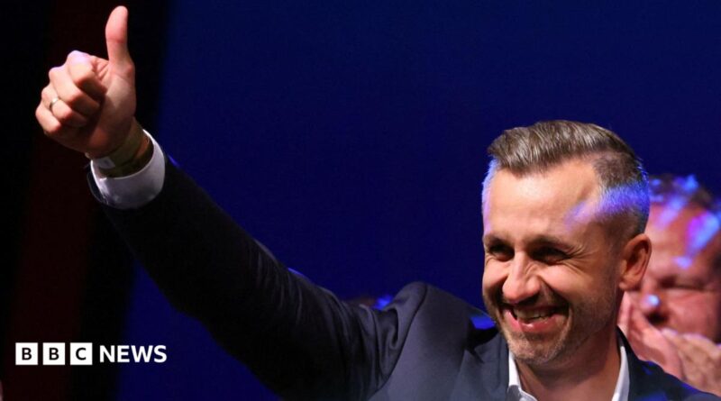 Ulrich Siegmund, leader of the AfD in the state, raises a thumbs up at the election party.
