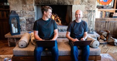 Thatch founders sitting on couch in front of fireplace
