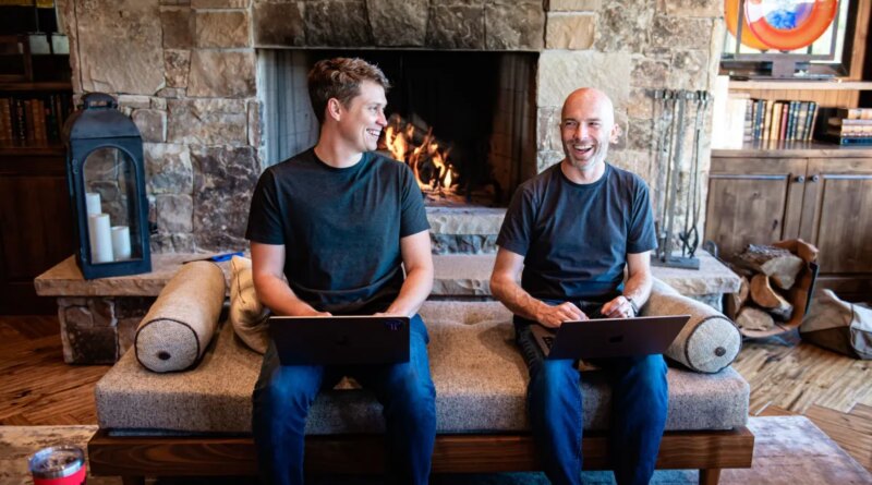 Thatch founders sitting on couch in front of fireplace