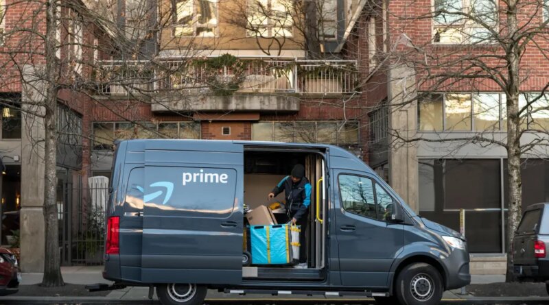 An Amazon driver looks for a package in a delivery van.