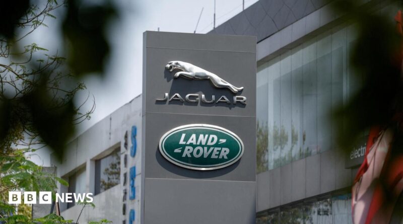 The silver leaping Jaguar emblem is on a grey pillar sign outside one of its factories with the green, oval Land Rover badge below.