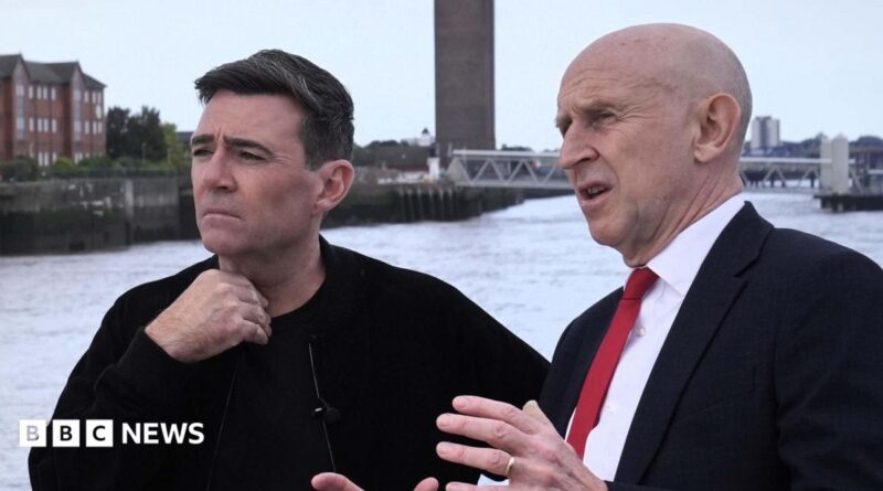 John Healey makes a point with his hands to a thoughtful looking Andy Burnham, who is gazing out across the Mersey river on a ferry in Liverpool